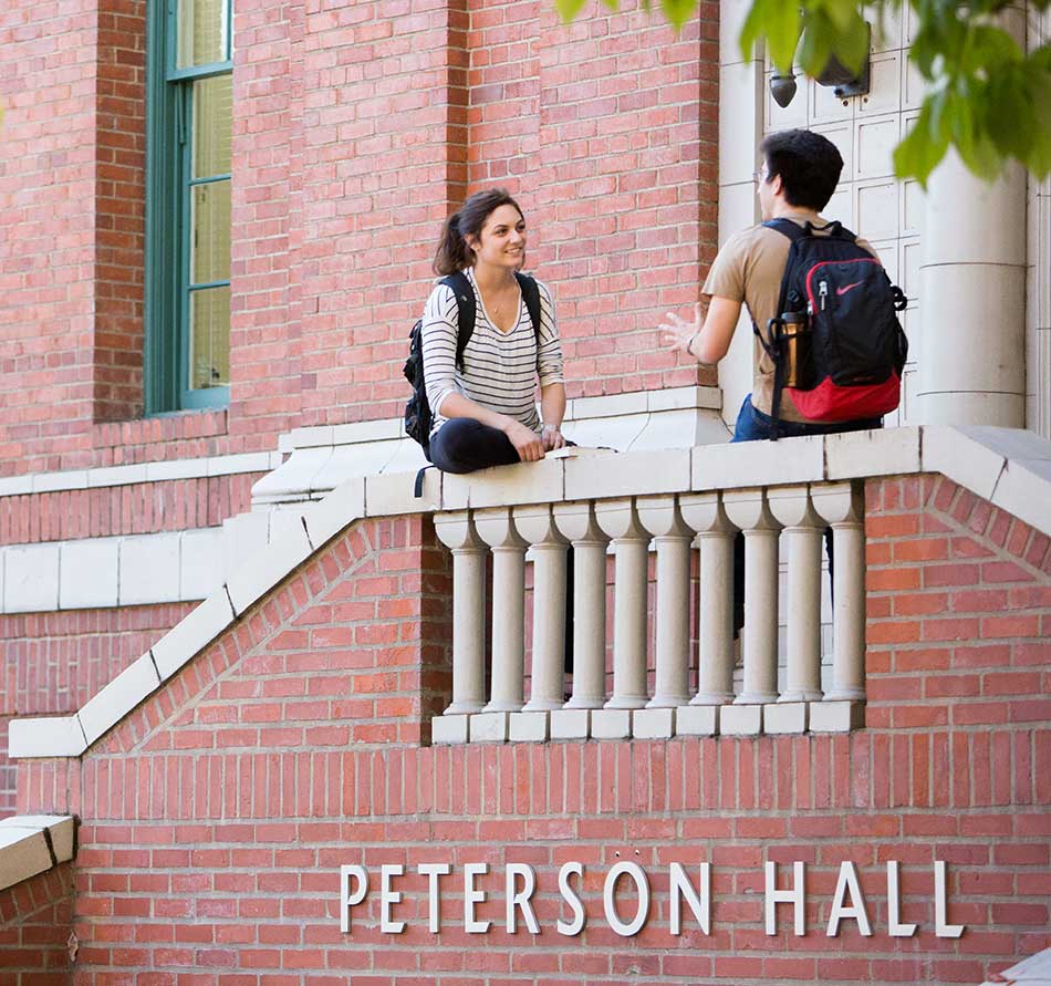 Two students sitting outside Peterson Hall Two students sitting outside Peterson Hall