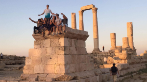 students sitting near ancient ruins