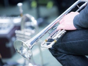 Close-up of musician's hand holding a silver trumpet.