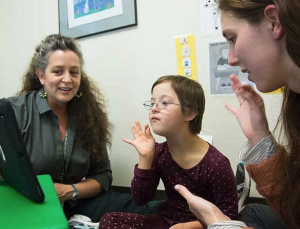 teachers showing young child a screen