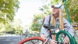 A student working on her bike on campus