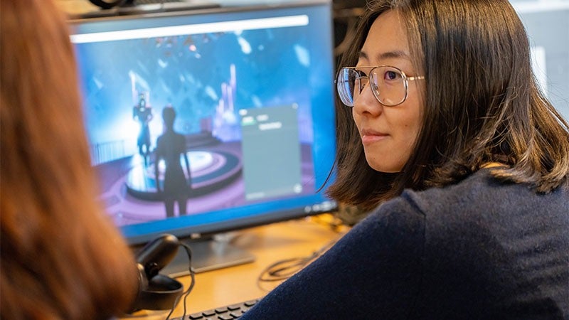 A student working on a computer in the VR lab