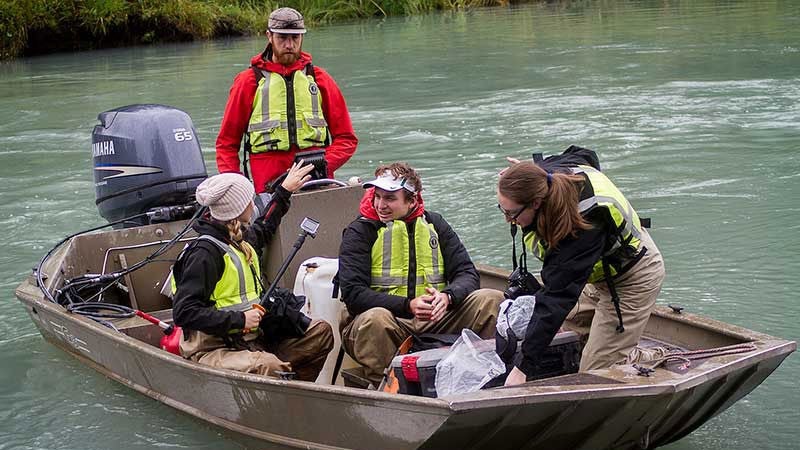 Students working in a boat on a river