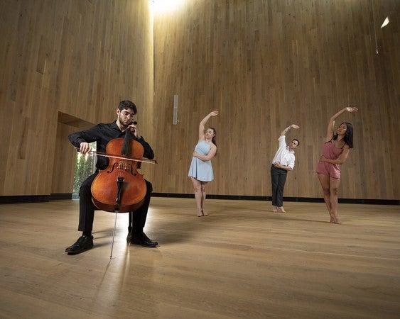A man plays a cello and three people dance in acoustically-designed environment of Berwick Hall