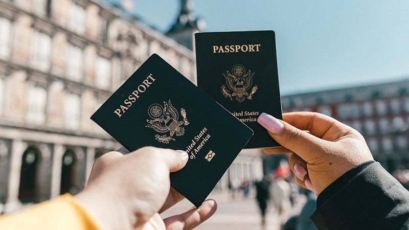 two people holding up their passports