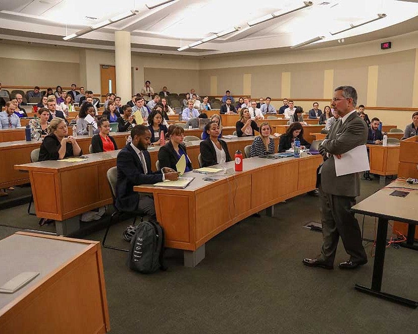 Male professor addressing diverse group of Juris Doctorate students in a lecture hall.