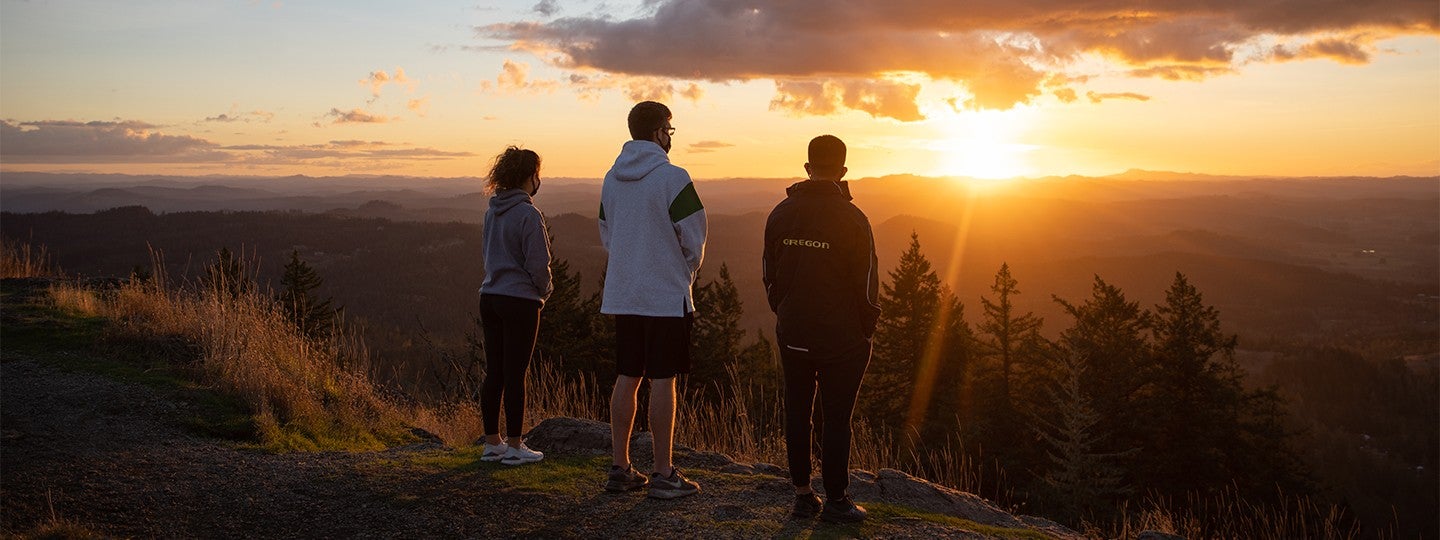 three UO students looking at Oregon sunset