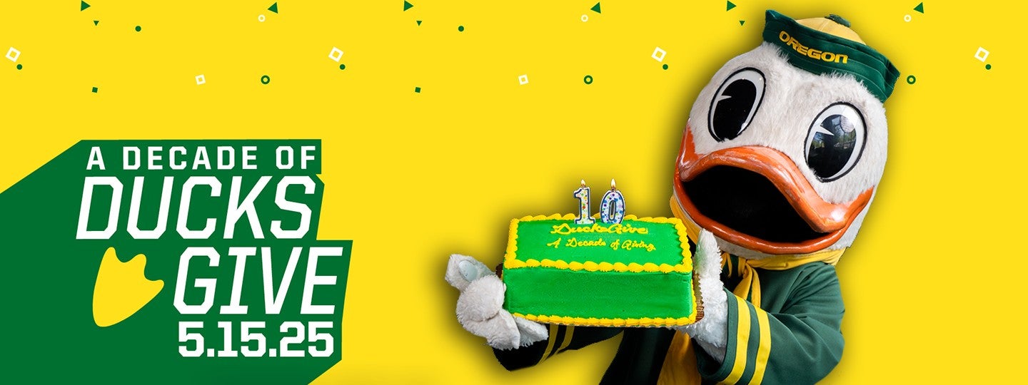 The Oregon Duck holding a cake with the text "A Decade of Ducks Give 5.15.25" next to them