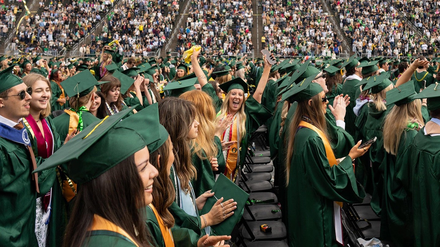 Uo graduates clapping during commencement ceremoy