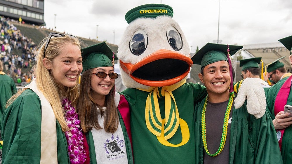 The Duck with three UO graduates at commencement