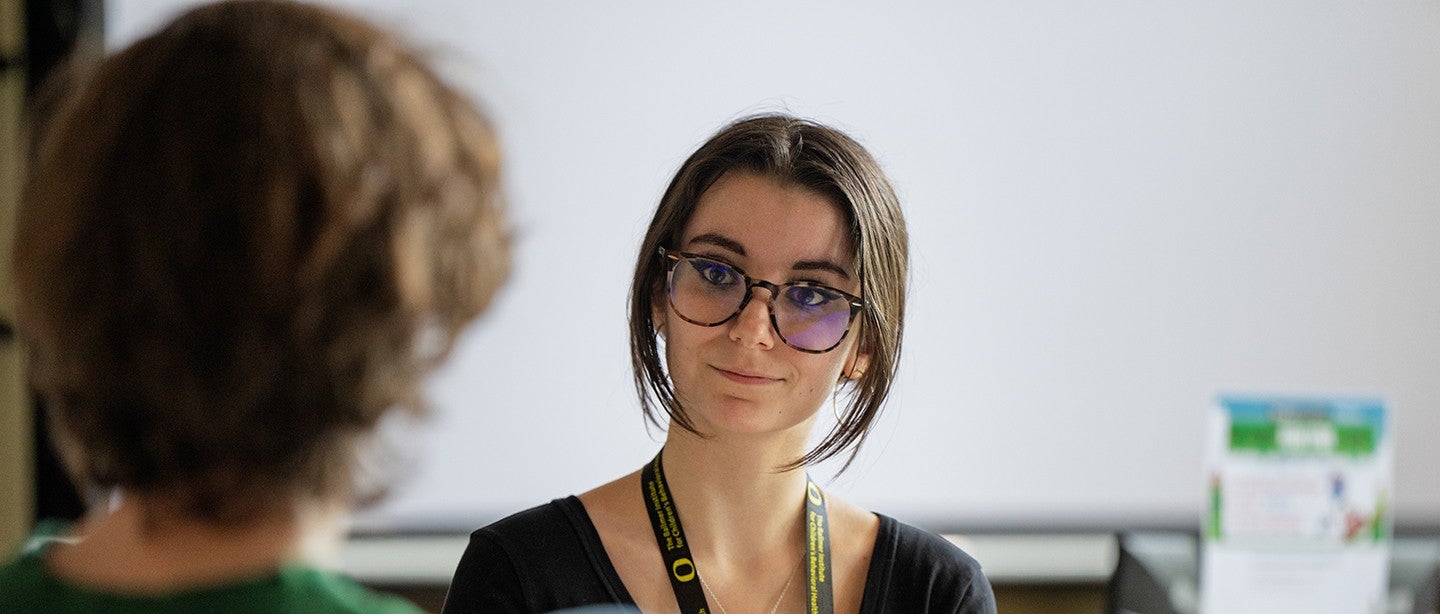 Female undergrad talking to a child during Ballmer clinical experience