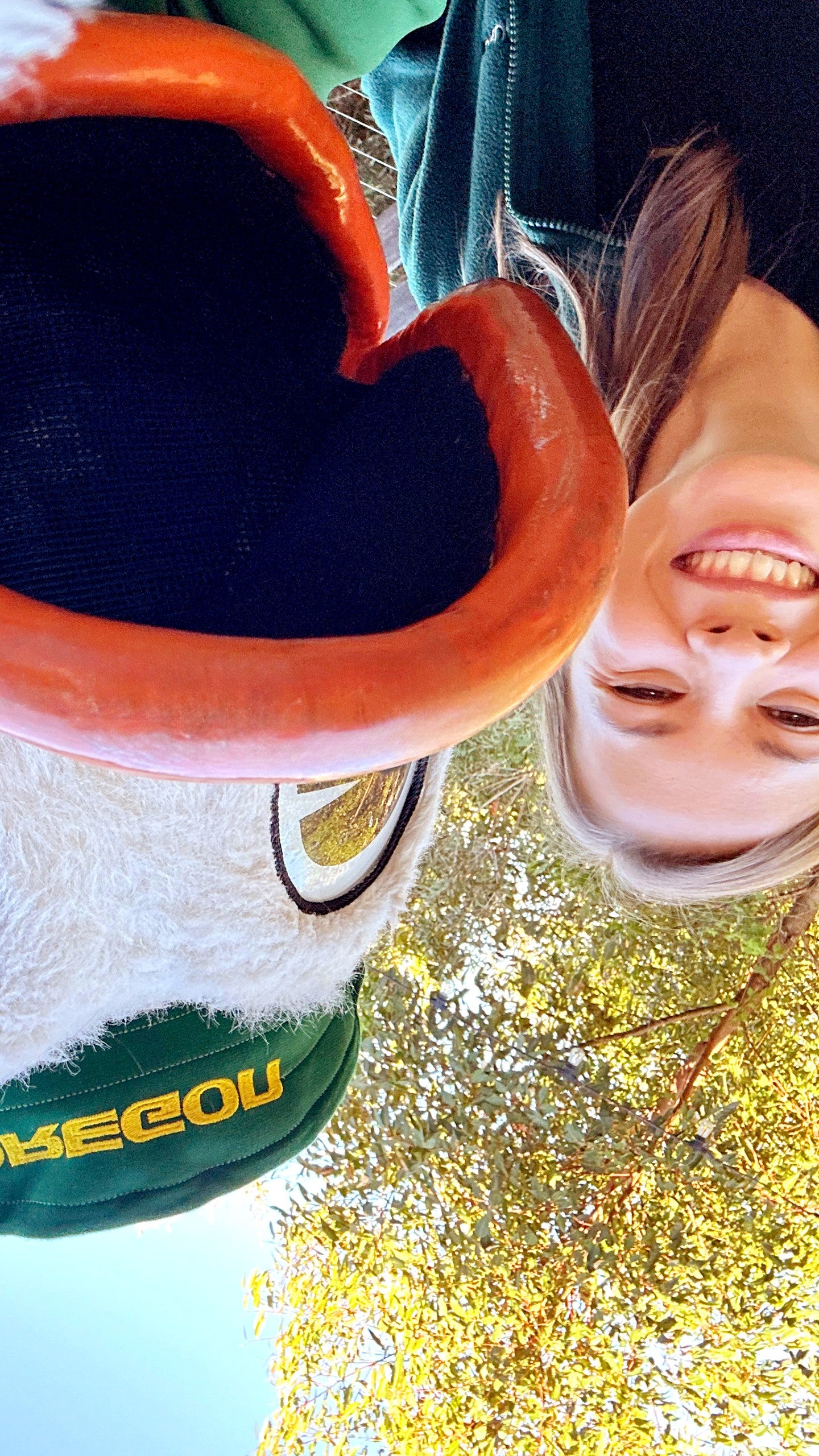 An upside down photo of the Oregon Duck taking a selfie with Bindi Irwin