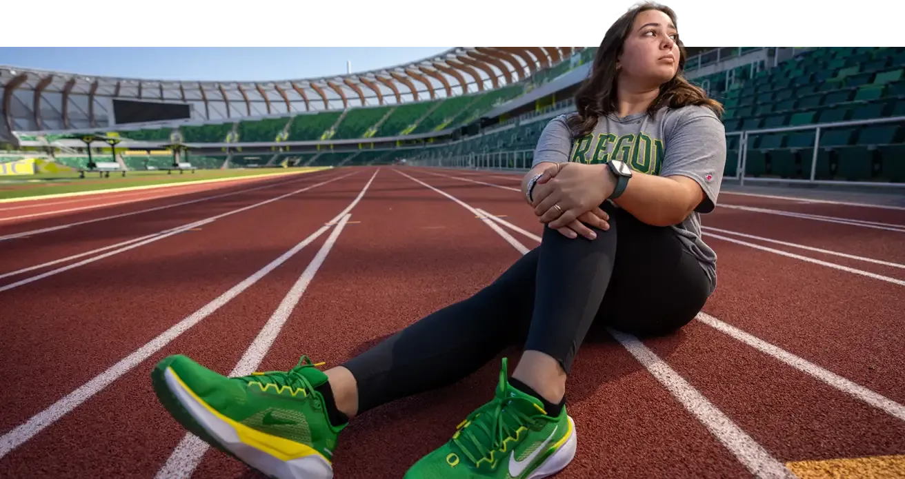 A runner sits on the track at Hayward Field.