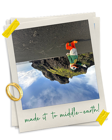 Upside down photo of the Oregon Duck walking on a beach with black sand