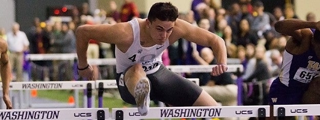 Devon Allen clears a hurdle during a race