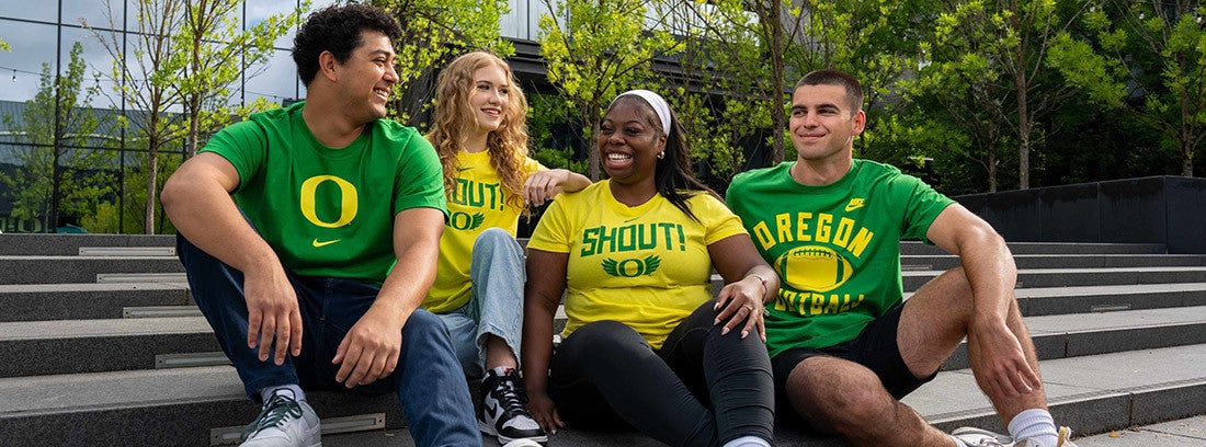 four people wearing yellow and green Ducks shirts