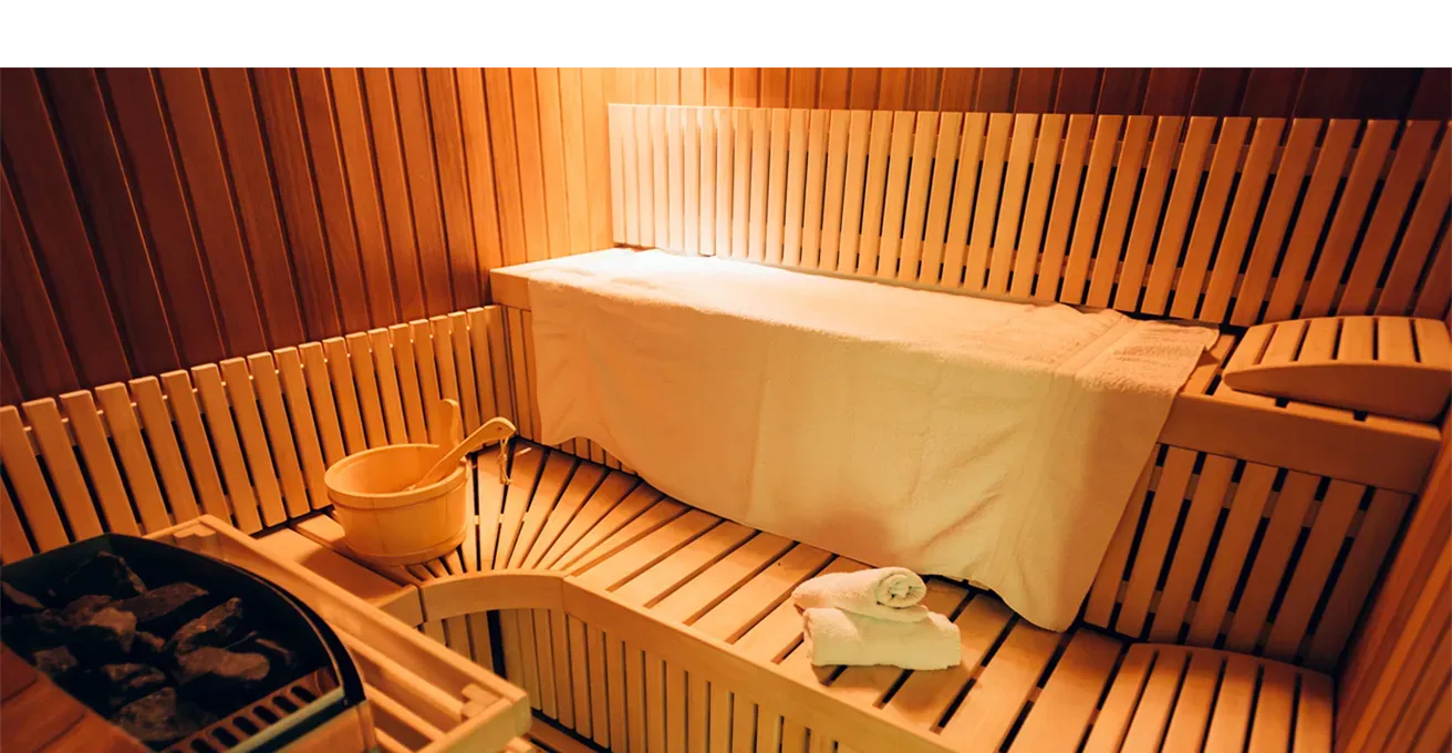 a wooden sauna room with towels, image courtesy Adobe Stock