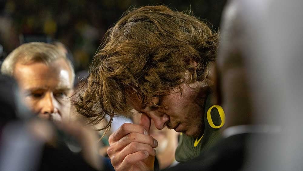 Justin Herbert hanging his head in emotion after the game