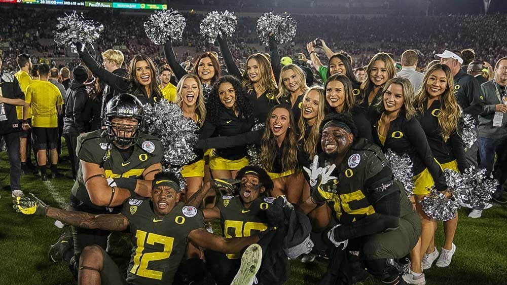 Oregon players and cheerleaders celebrate after the game