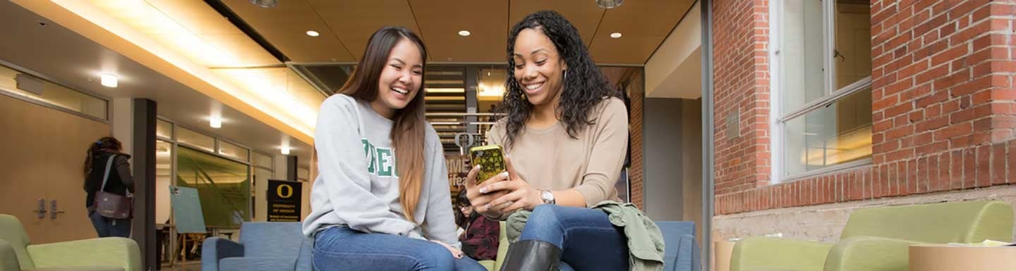 Two female students looking at a phone