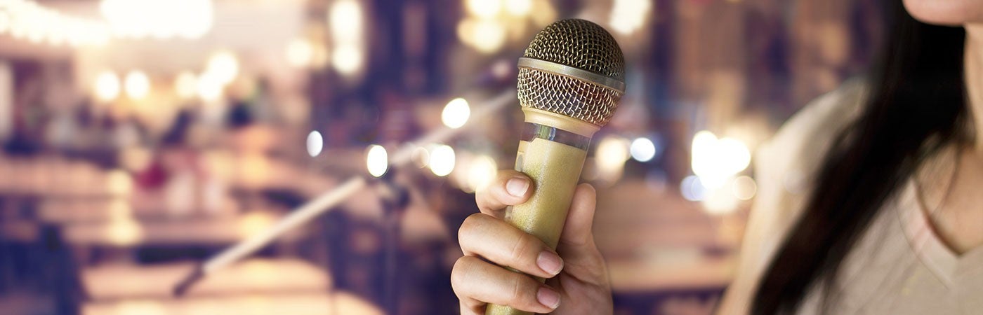 Woman holding a microphone in a pub Woman holding a microphone in a pub