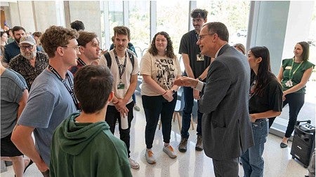 UO President Karl Scholz speaking with a student group