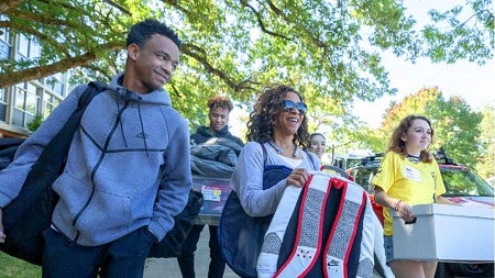 Black family helping their student move in to the UO dorms