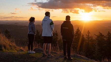 three UO students looking at Oregon sunset