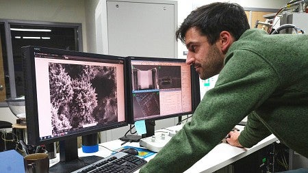 Paul Kempler examines scanning electron microscope images on a computer screen