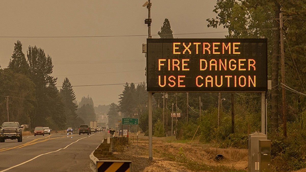 Caution sign on the road that says "Extreme Fire Danger Use Caution"