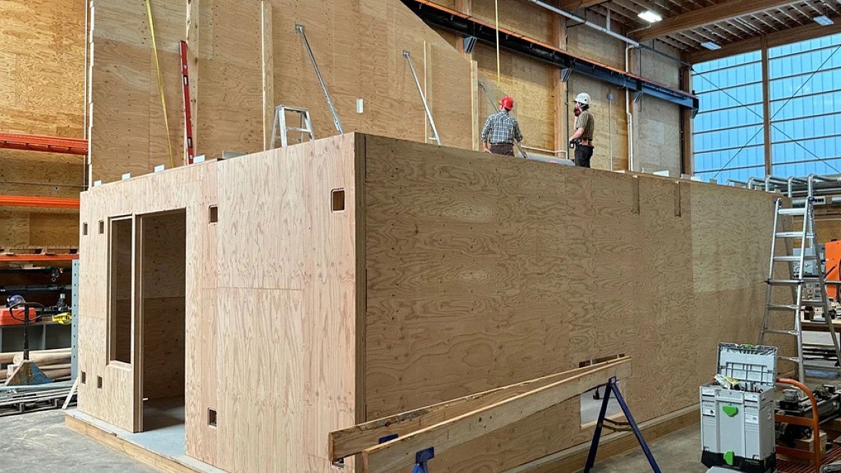 Two builders on top of a mass timber prototype home