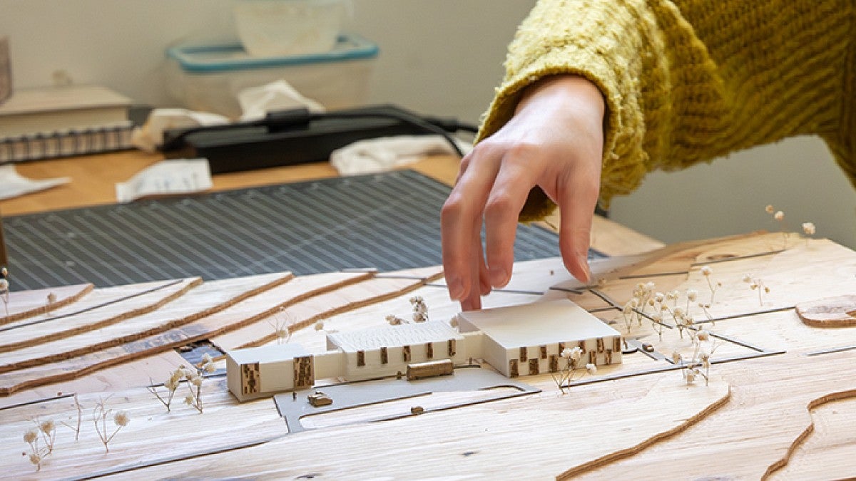 A hand holding wood prototype pieces