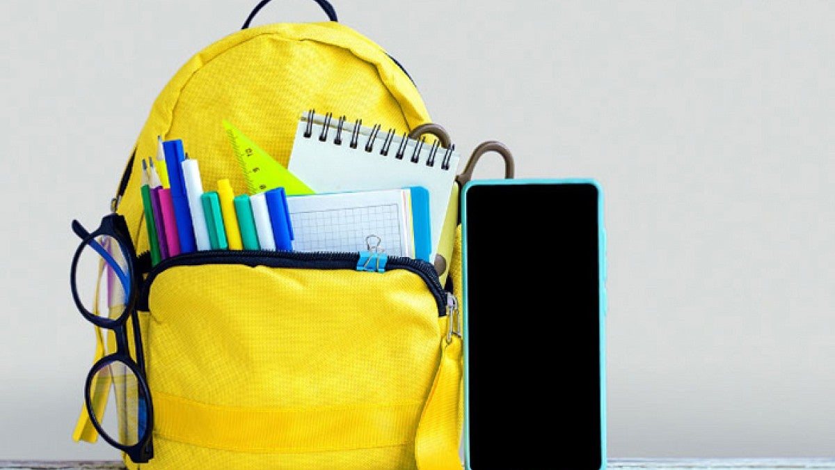 Yellow backpack with pens and school supplies in it