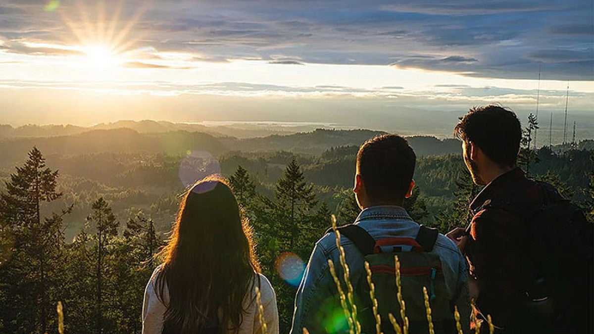 three people watching a sunset over the Willamette Valley