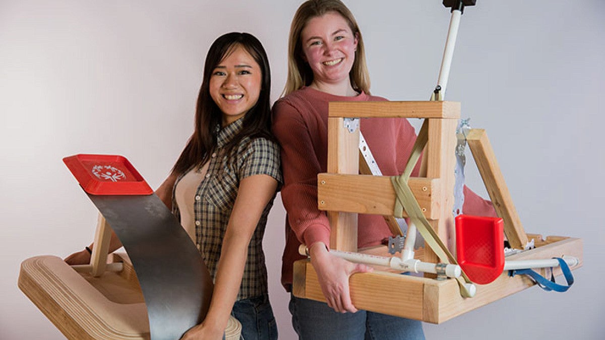 two students holding launching devices