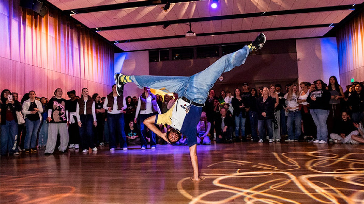 a person dancing in front of a crowd at a hip-hop gathering