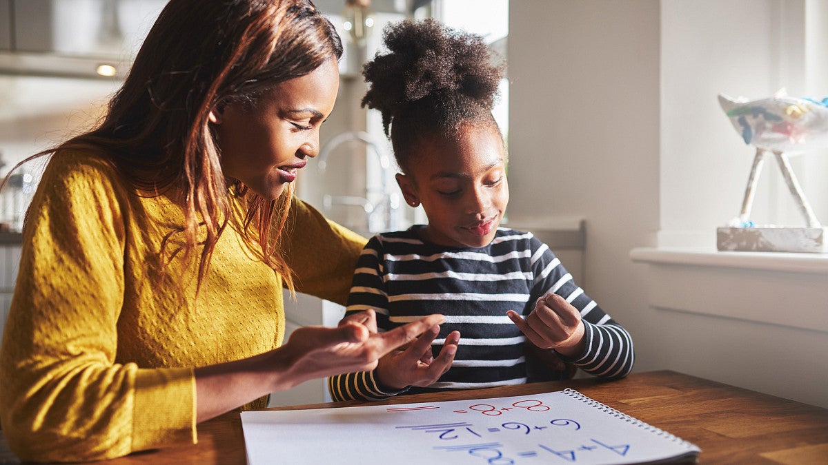 A mother working on a math problem with her child