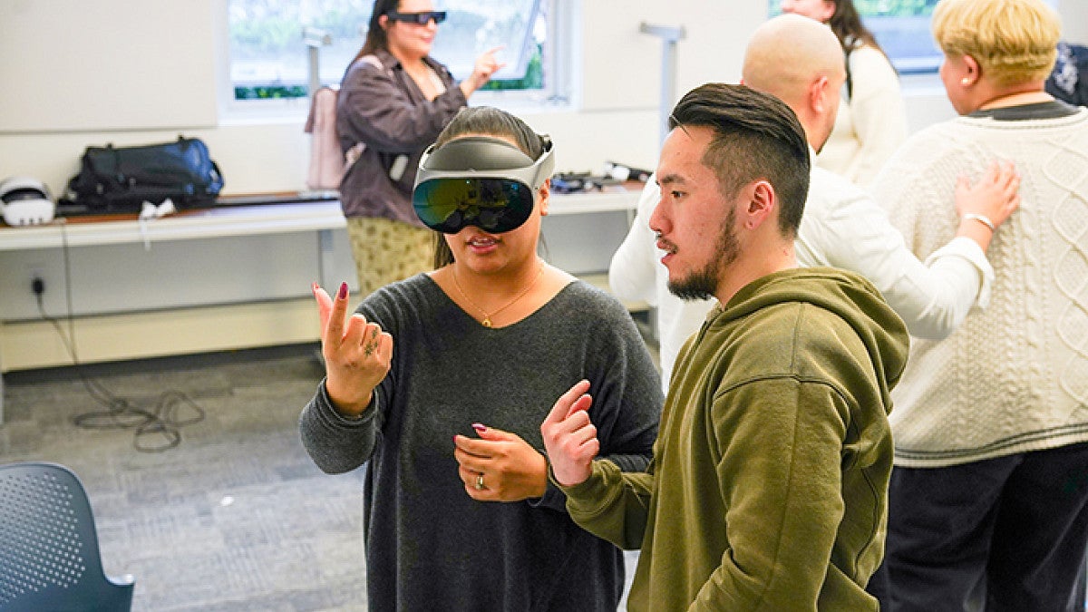 a person wearing a virtual reality headset receives instruction on hand tracking