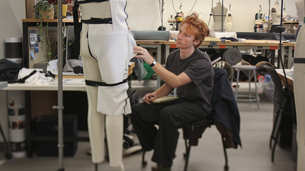 Jacob Kauff adds fabric to a mannequin while doing design work