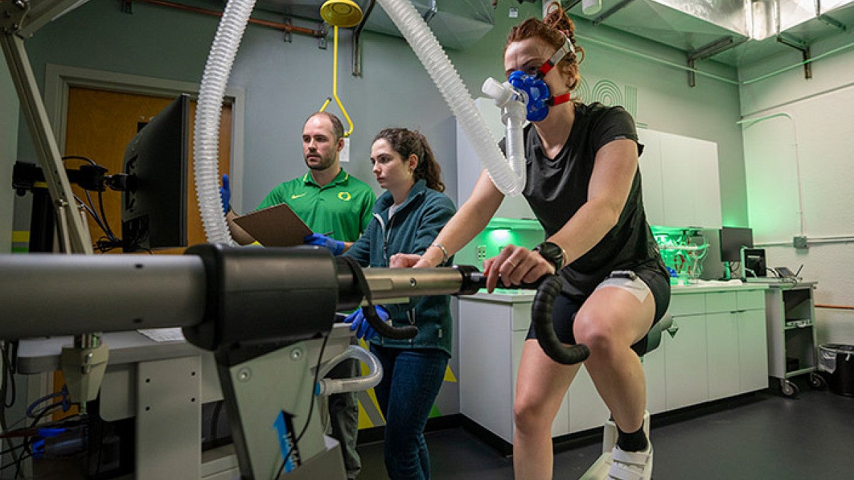 scientists collecting data on an athlete on a stationary bike