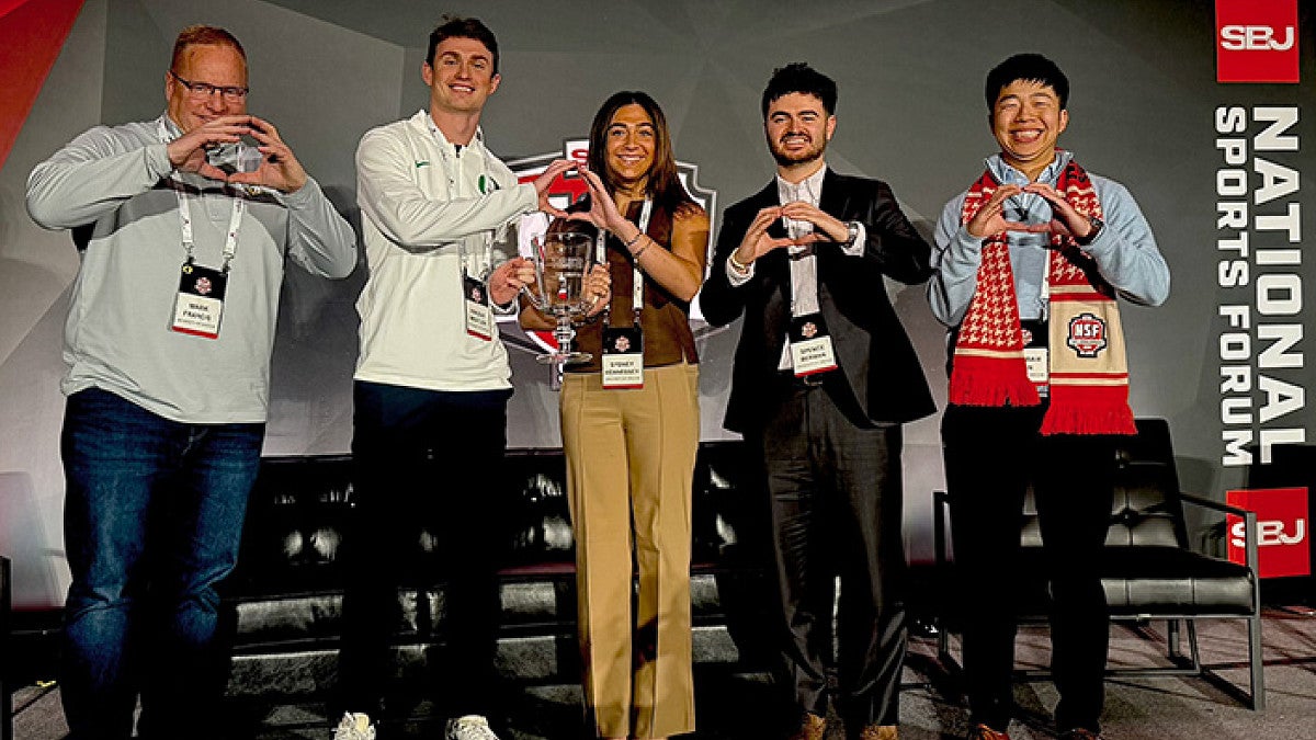 four students and a faculty member pose for a group photo at the Sports Business Journal National Sports Forum