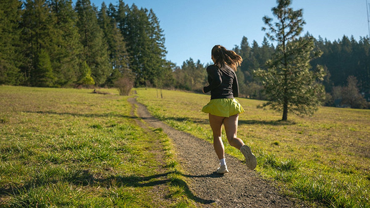 a person running on a trail in a natural area