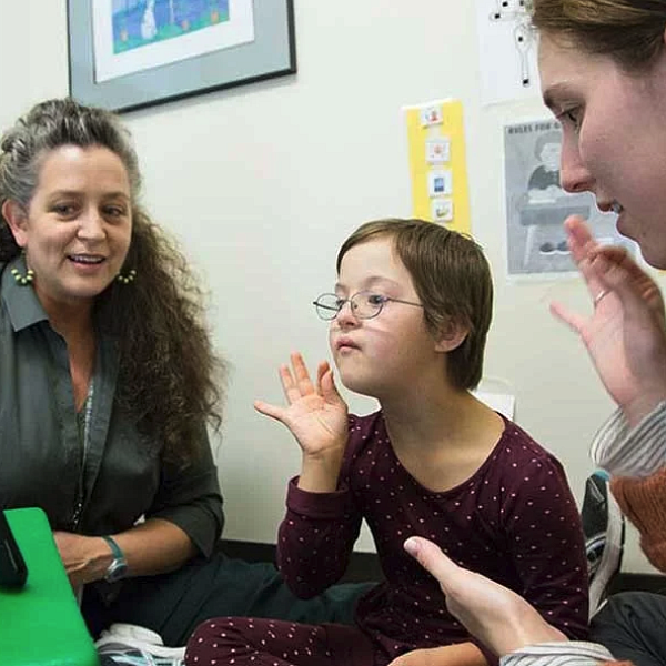 teachers showing young child a screen
