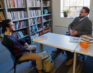 Faculty members mentor their students in the Clark Honors College A student speaking with a professor in their office