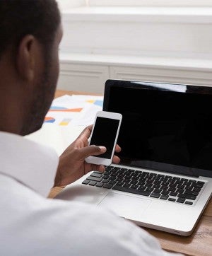 A man working on his phone and computer