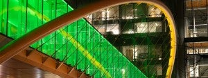 Knight Campus Skybridge lit in green and yellow at night