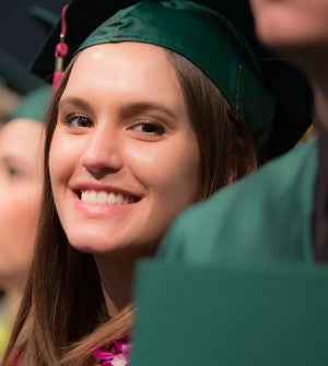 Female graduate in cap and gown at commencement