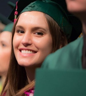 Female graduate in cap and gown at commencement Female graduate in cap and gown at commencement