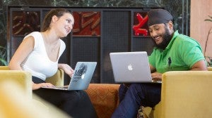 Two students on computers talking
