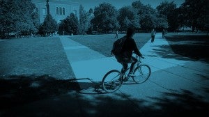 Student riding her bike through the Quad